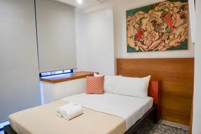 a small room with a bed and a painting on the wall at Cayco House by Hotel Durban in Manila