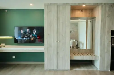 a living room with a tv on a wall at BGC Suite with Golf Course View in Manila