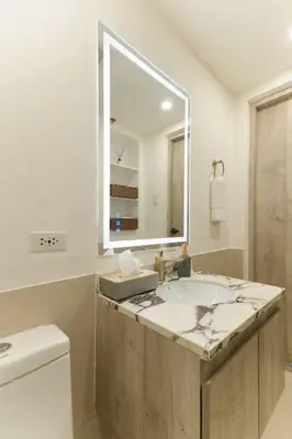 a bathroom with a sink and a mirror at BGC Suite with Golf Course View in Manila
