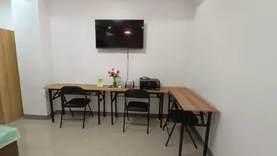 a table with chairs and a television on a wall at Masterpiece Staycation Makati in Manila