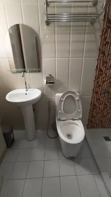 a small bathroom with a toilet and a sink at Masterpiece Staycation Makati in Manila