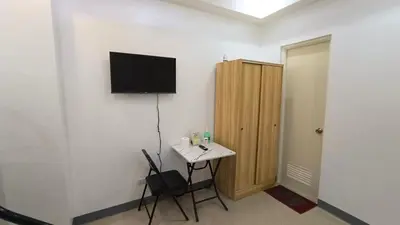 a room with a small table and a television on the wall at Masterpiece Staycation Makati in Manila