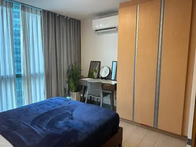 a bedroom with a bed and a desk with a computer at Deluxe Suite in One Uptown, BGC with Mall Fountain View in Manila