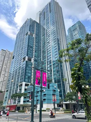 a tall building with a pink sign in front of it at Deluxe Suite in One Uptown, BGC with Mall Fountain View in Manila