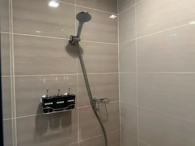 a shower with a shower head in a bathroom at Deluxe Suite in One Uptown, BGC with Mall Fountain View in Manila