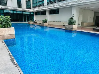 a large blue swimming pool in a building at Deluxe Suite in One Uptown, BGC with Mall Fountain View in Manila