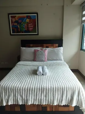 a bedroom with a bed with two slippers on it at Palm Tree Villas - Studio Unit in Manila