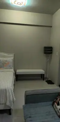 a room with a bed and a bench in it at Palm Tree Villas - Studio Unit in Manila