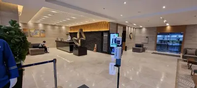 a lobby of a hotel with a man sitting at a counter at Premier Luxury Suite near SM Mall of Asia Arena & DFA with Free Parking in Manila