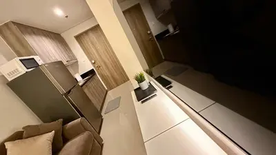 a small room with a couch and a refrigerator at Premier Luxury Suite near SM Mall of Asia Arena & DFA with Free Parking in Manila