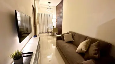 a living room with a couch and a television at Premier Luxury Suite near SM Mall of Asia Arena & DFA with Free Parking in Manila