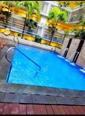 a large blue swimming pool in front of a building at Rose condotel Newport in Manila