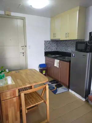 a kitchen with a wooden table and a refrigerator at Rose condotel Newport in Manila