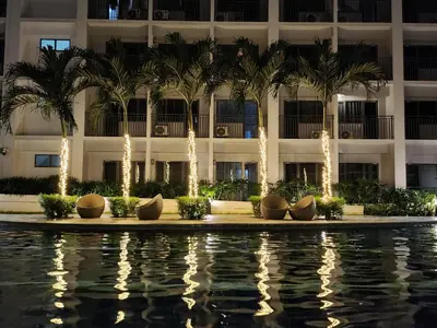 a hotel with palm trees in front of a building at Goshen E320 in Manila