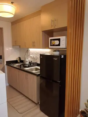 a kitchen with a black refrigerator and a microwave at Goshen E320 in Manila