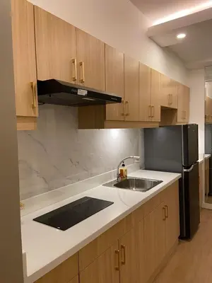 a kitchen with a sink and a black refrigerator at Luxury 1 BR Suite Near NAIA in Manila