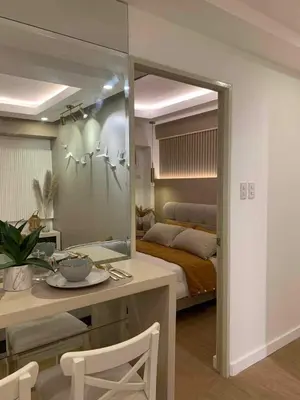 a bedroom with a mirror and a table and a bed at Luxury 1 BR Suite Near NAIA in Manila