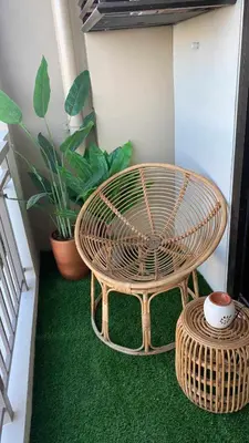 a wicker table and stool in a room with plants at Luxury 1 BR Suite Near NAIA in Manila