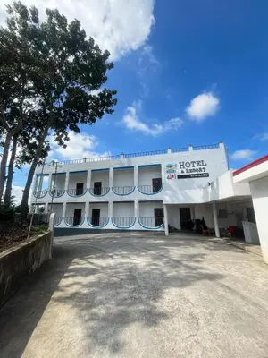 a large white building with a tree in front of it at Shiri Hotel in Silang