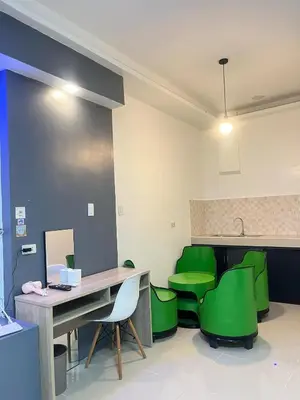 a waiting room with green chairs and a desk at Shiri Hotel in Silang