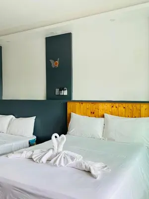 a bedroom with two beds with white sheets at Shiri Hotel in Silang