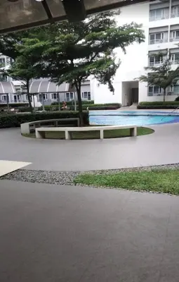 a park with a bench and a tree and a building at Grace Residences Pool View Free Wi-Fi near BGC and McKinley 2050 in Manila