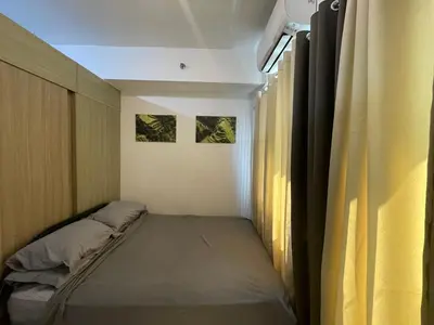 a small room with a bed and a window at Grace Residences Pool View Free Wi-Fi near BGC and McKinley 2050 in Manila