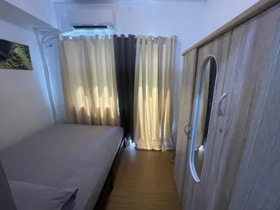 a small room with a bed and curtains at Grace Residences Pool View Free Wi-Fi near BGC and McKinley 2050 in Manila