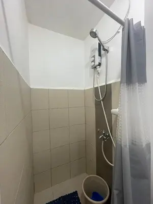 a shower in a bathroom with a shower curtain at Grace Residences Pool View Free Wi-Fi near BGC and McKinley 2050 in Manila