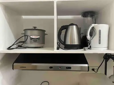 a shelf with pots and pans and a blender at Grace Residences Condotel Paris & Singapore Concept Near McKinley in Manila