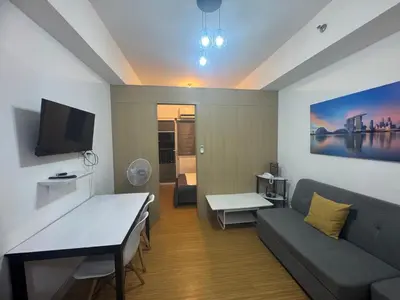 a living room with a couch and a tv at Grace Residences Condotel Paris & Singapore Concept Near McKinley in Manila