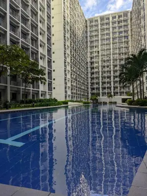 a large swimming pool in front of two tall buildings at Shore 2 Residences T1, MoA WTC SMX Arena 1br 4pax in Manila