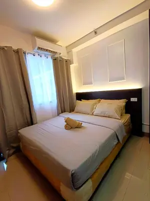 a bed with a yellow shoe sitting on top of it at Shore 2 Residences T1, MoA WTC SMX Arena 1br 4pax in Manila