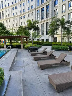 a patio with lounge chairs and a table in front of a building at 81 Newport Blvd Cluster 4 Unit B 3rd flr by Rechelle Nunag in Manila