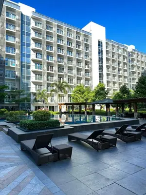 a row of lounge chairs in front of a large building at 81 Newport Blvd Cluster 4 Unit B 3rd flr by Rechelle Nunag in Manila