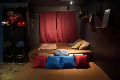 two beds in a room with a red curtain at EL MEIR STAYCATION SMART CINEMA CABIN BESIDE ENCHANTED KiNGDOM in Santa Rosa