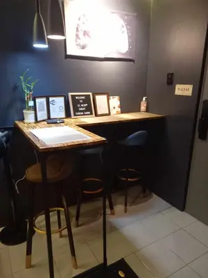 a bar with stools and a table in a room at EL MEIR STAYCATION SMART CINEMA CABIN BESIDE ENCHANTED KiNGDOM in Santa Rosa