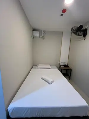 a small room with a white bed in a room at Maine City Residences Tramo in Manila