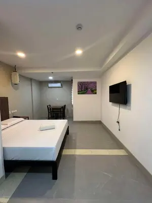 a bedroom with a bed and a tv on a wall at Maine City Residences Tramo in Manila