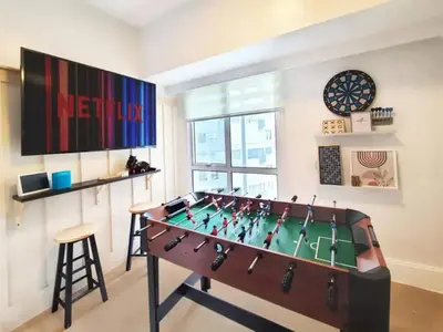 a living room with a foosball table in the middle at BGC - Two Bedroom Condo with Game Room high speed WiFi in Manila