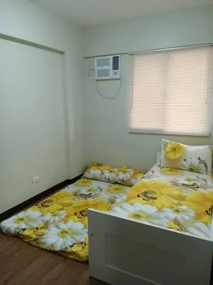 a bedroom with a large bed with flowers on it at Asteria Residences Annabel CozyPlace highspeed wifi in Manila