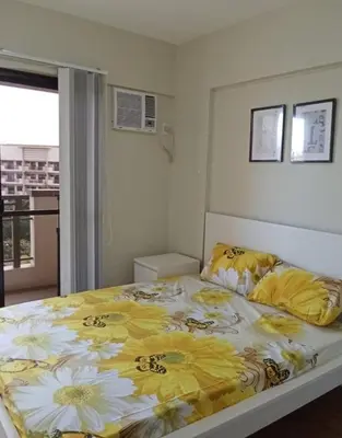 a bedroom with a large bed with flowers on it at Asteria Residences Annabel CozyPlace highspeed wifi in Manila