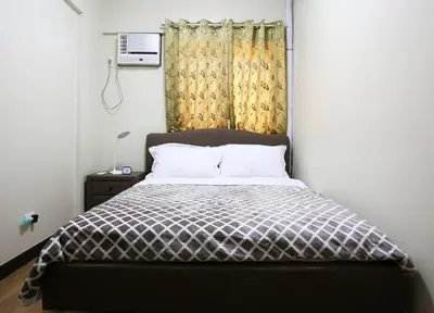 a bedroom with a bed and a window and a bedskirtspectspectspectspects at Asteria Residences Annabel CozyPlace highspeed wifi in Manila