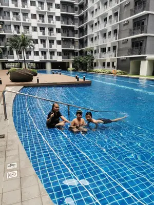 three people are sitting in a swimming pool at Shore 3 tower 2 mall of Asia in Manila