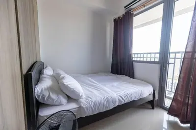 a bed in a room with a large window at Bohemian 1-BR Condo in Mandaluyong in Manila