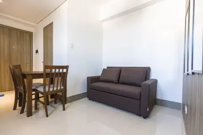 a living room with a couch and a table and chair at Bohemian 1-BR Condo in Mandaluyong in Manila