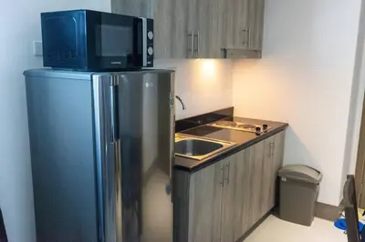 a kitchen with a microwave on top of a refrigerator at Bohemian 1-BR Condo in Mandaluyong in Manila