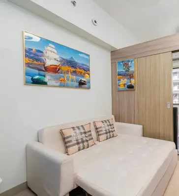 a white couch in a room with a painting on the wall at MALL OF ASIA Condo with Balcony Facing Pool @ Shore2 in Manila