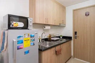 a kitchen with a white refrigerator and a sink at MALL OF ASIA Condo with Balcony Facing Pool @ Shore2 in Manila