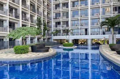 a swimming pool in front of a building at MALL OF ASIA Condo with Balcony Facing Pool @ Shore2 in Manila
